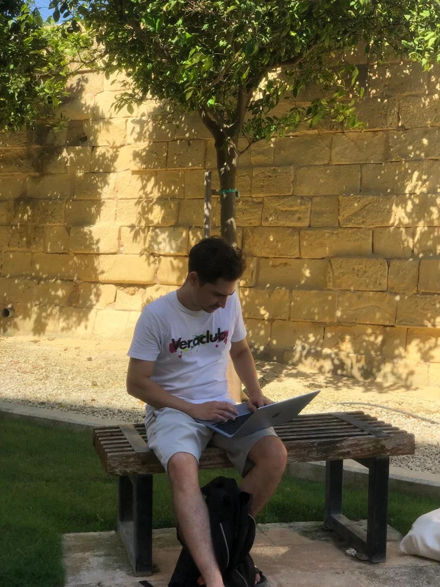 Damian working on his laptop outdoors